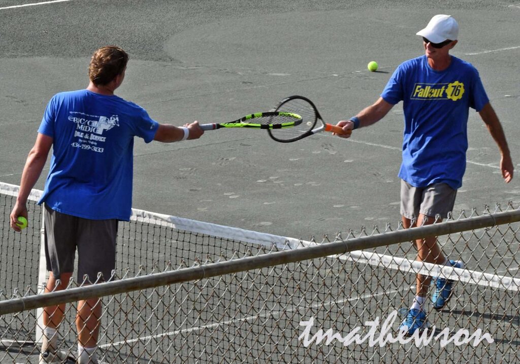 two men preparing to begin their tennis lesson